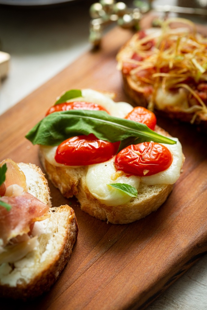 BRUSQUETTA DE MUSSARELA DE BUFALA, TOMATE CONFIR E RUCULA (6 UNIDADES)